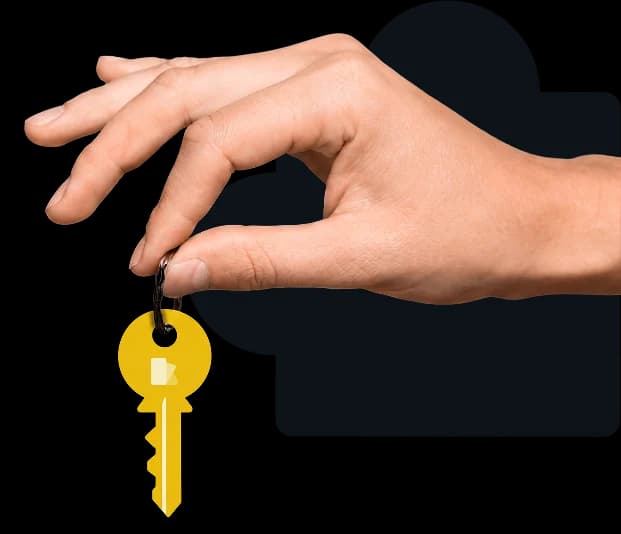 A hand holding a gold house key